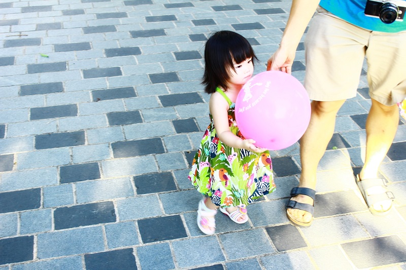 Children are very cute in Singapore. I took this photo at the Bishan-Ang Mo Kio Park, Singapore. This little girl was trying to control the balloon, and kept losing her own control in this process. :)