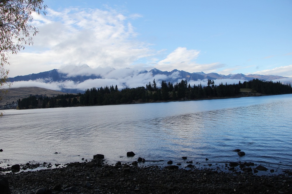 Queenstown scenery- Mountains, clouds, and lake.