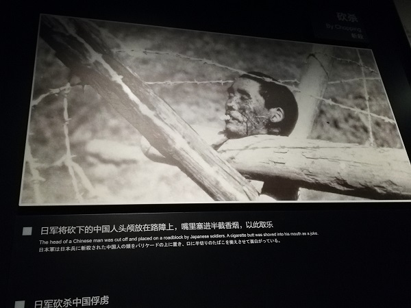 The photo caption reads- “The head of a Chinese man was cut off and placed on a roadblock by Japanese soldiers. A cigarette butt was shoved into his mouth as a joke”.