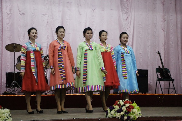 High school students preforming in traditional Korean dress.
